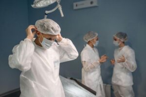 man in protective suit putting on a face mask beside two other people 300x200 - man in protective suit putting on a face mask beside two other people