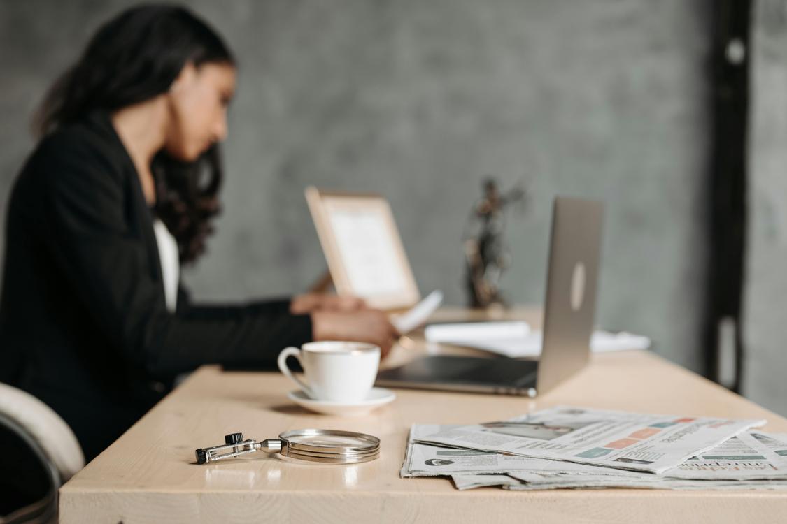 woman working at the desk in office - 7 Benefits of Hiring a Criminal Defense Attorney