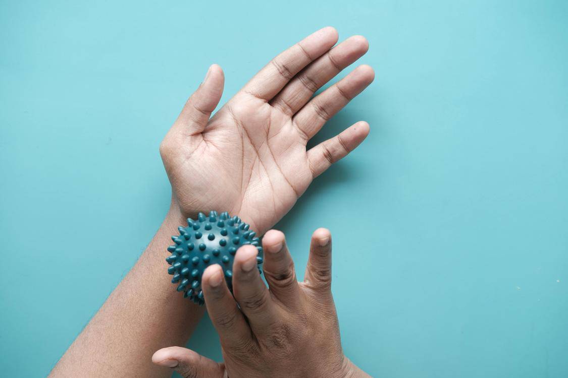 hands with massage ball - Benefits of Chiropractic for Seniors' Health