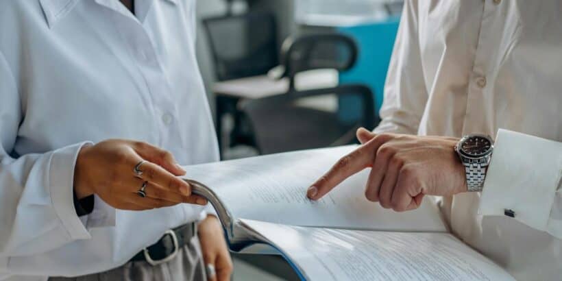 colleagues standing in white long sleeve shirts discussing and reading something 820x410 - Why Most Startups Fail and the Legal Pitfalls They Face