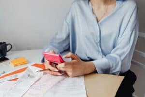 woman holding a pink calculator 300x200 - woman holding a pink calculator