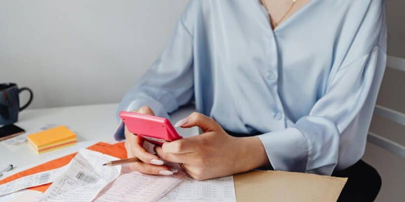 woman holding a pink calculator 820x410 - How to Improve Your Law Firm's Bookkeeping Efficiency