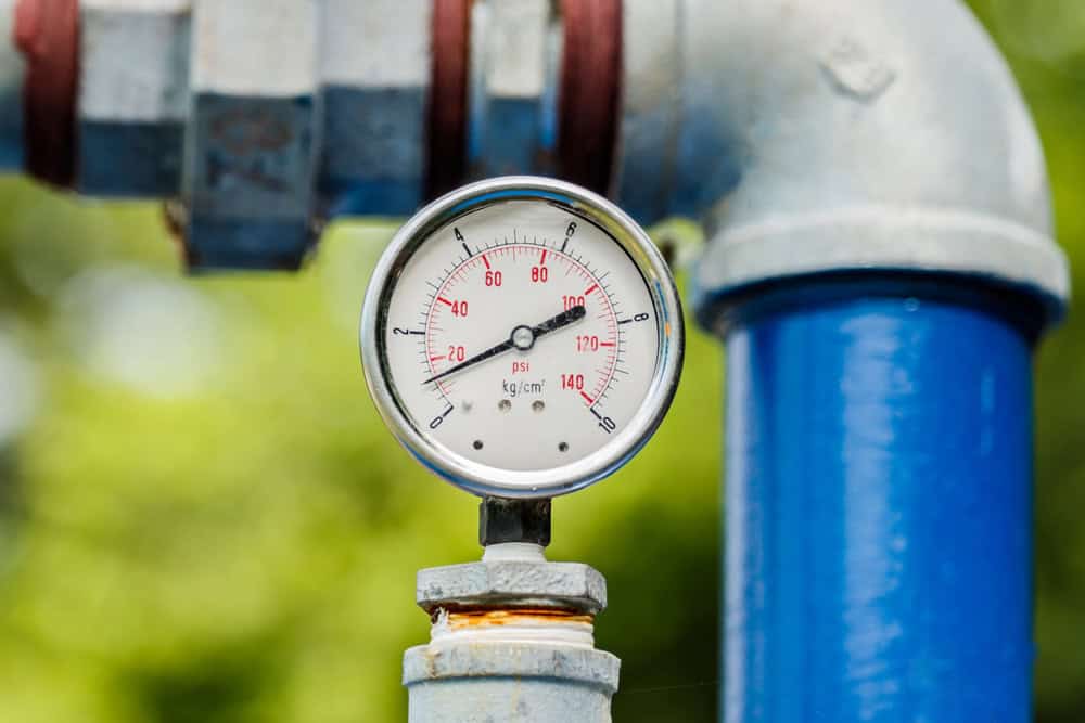 water pressure gauge near a blue pipe - 5 Fixes for Poor Water Pressure in Your Kitchen or Bathroom