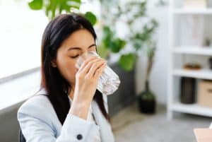 a woman drinking a glass of water 300x201 - a woman drinking a glass of water