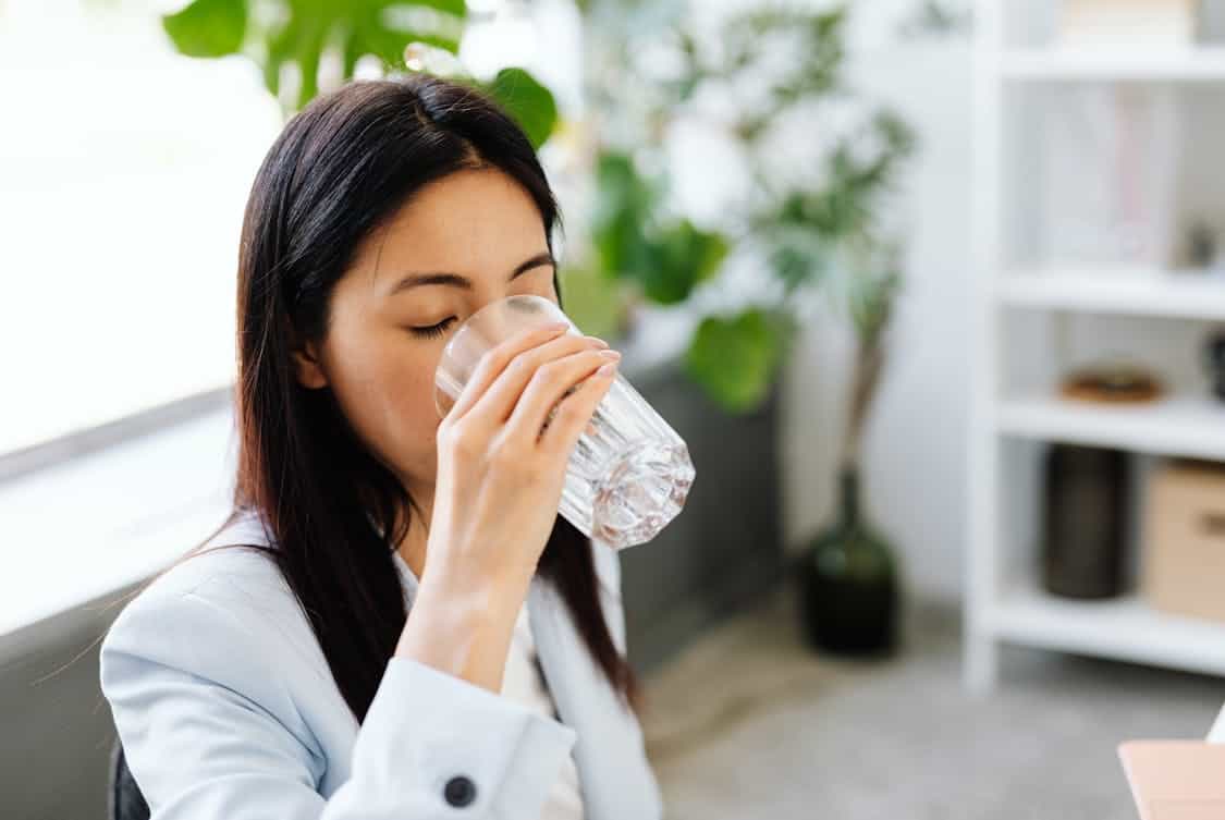 a woman drinking a glass of water - How to Care For Your Skin Post-botox Injection Sessions